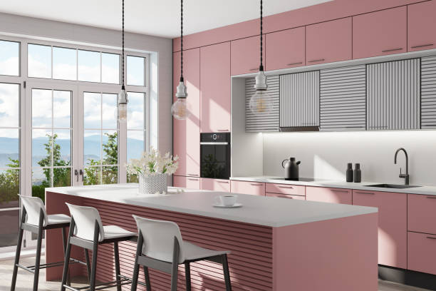 istock Light pink and gray Modern Scandinavian kitchen with large kitchen island with stools. Large windows. Open space kitchen concept. Summer scene. 1313916981