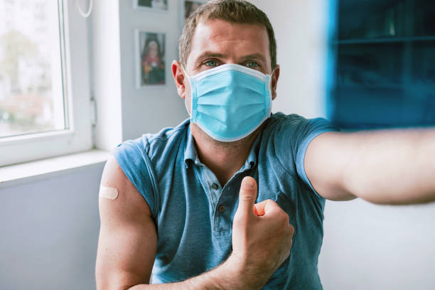 istock Man wearing protective face mask taking a selfie after vaccination against Covid-19 1313917617