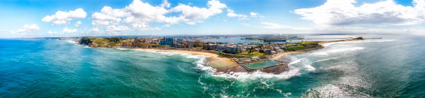 D Newcastle from pool day WIde aerial panorama of Newcastle city coast in Australia from Pacific ocean around Newcastle beach from Nobbys head. newcastle new south wales photos stock pictures, royalty-free photos & images