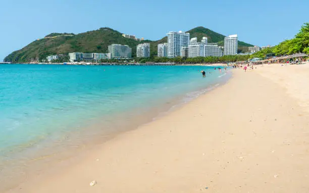 Scenic view of Dadonghai white sand beach with blue sky and Luhuitou peninsula view in Sanya Hainan island China