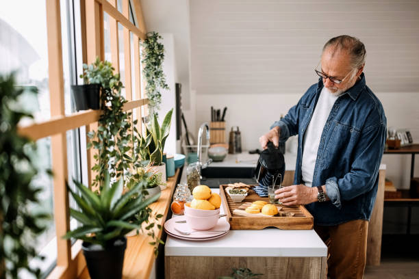 istock Senior man making cup of tea at home 1313927462
