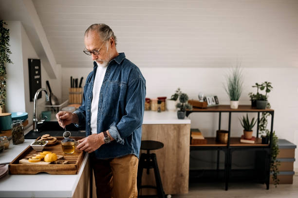 istock Senior man making cup of tea at home 1313928444