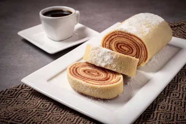 Delicious roll cake with guava jam and a cup of black coffee.