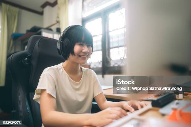 Young Adult Asian Woman Wear Headphone Using Computer Communication Via Internet Online Technology Stock Photo - Download Image Now