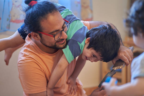 istock Father and son laugh while assembling wooden desk. Assembling furniture at home. Father session 1313944013