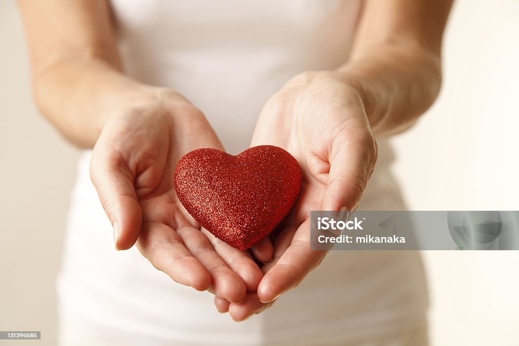 Giving love Giving love concept with hands holding a red heart. Adult Stock Photo