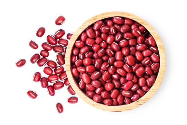 Red small Azuki beans ( Adzuki or japanese red bean ) in wooden bowl isolated on white Red small Azuki beans ( Adzuki or japanese red bean ) in wooden bowl isolated on white background. Top view. Flat lay. adzuki bean photos stock pictures, royalty-free photos & images