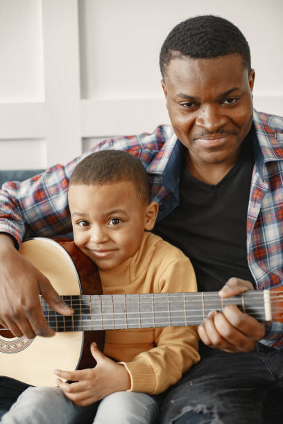 istock Father teaches his son to play guitar 1313948210