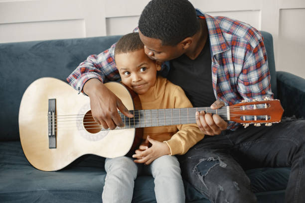 istock Father teaches his son to play guitar 1313948213
