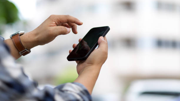 istock Male hands texting message on smartphone while outdoor standing 1313950013