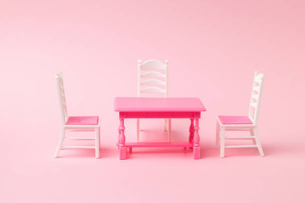 istock Three chairs near a red table on a pink background. 1313955044