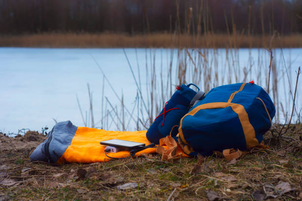 istock Smartphone is charged using a portable charger. Power Bank charges the phone outdoors with a backpack for tourism in the background of nature and the river. 1313955832