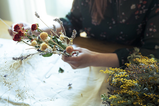 A woman making a swag with dried flowers