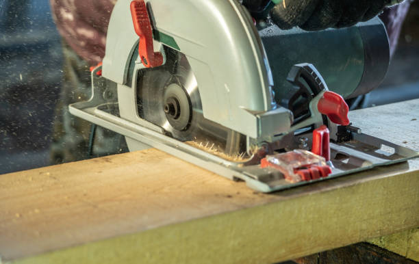 istock Worker carpenter is sawing a wooden Board with a hand-held circular saw 1313961399