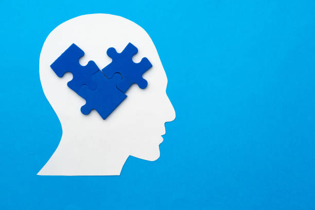 istock Papercut head with jigsaw puzzle pieces on blue background 1313964060