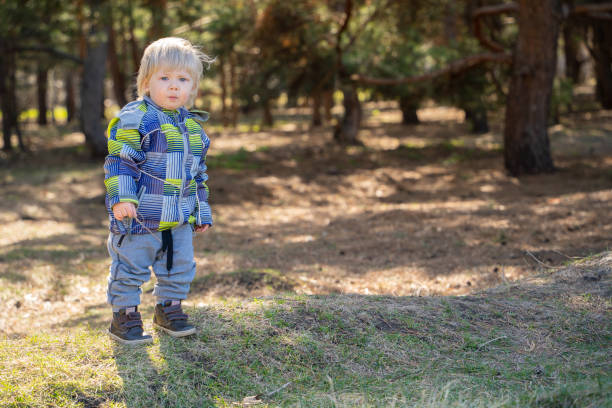 istock A one-year-old boy with blond hair in a spring forest looks thoughtfully into the camera. 1313969694