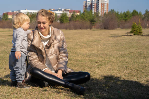 istock Mother and son bask in the spring sun on the lawn. 1313969728
