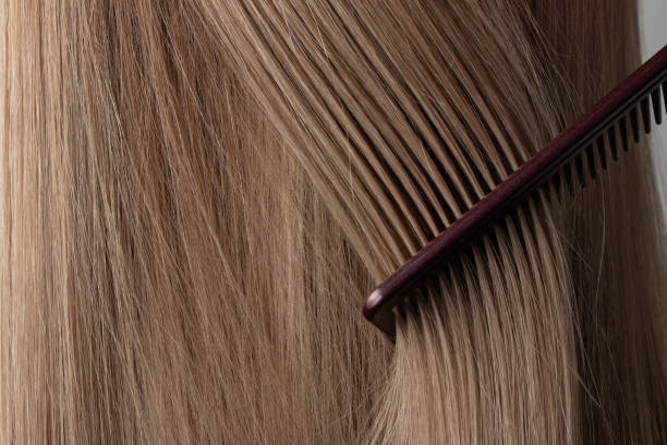 istock Brushing hair with a comb close up. 1313970781