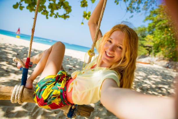 행복한 젊은 여자 와 빨간 머리 웃음 과 스윙 에 스윙 - thailand beach island tropical climate 뉴스 사진 이미지