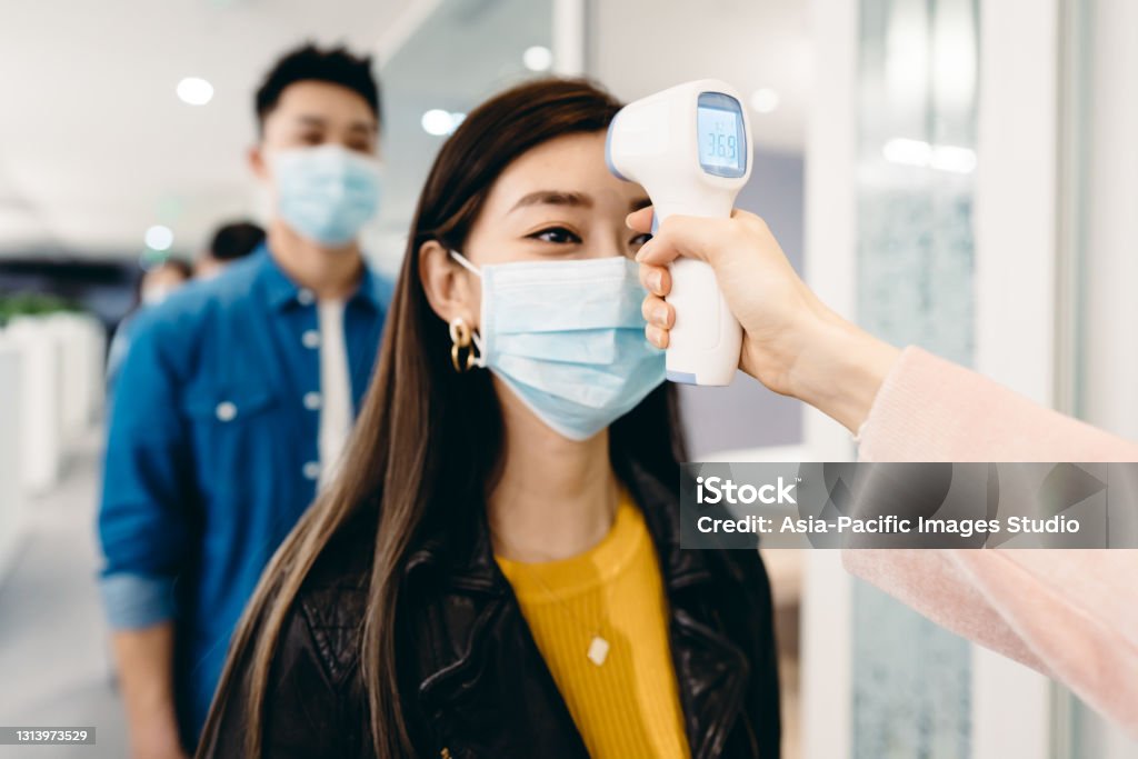 Asian business people measuring temperature in the office. Adults Only, Business, Business Person, China - East Asia, Korea, Japan, Cold Temperature China - East Asia Stock Photo