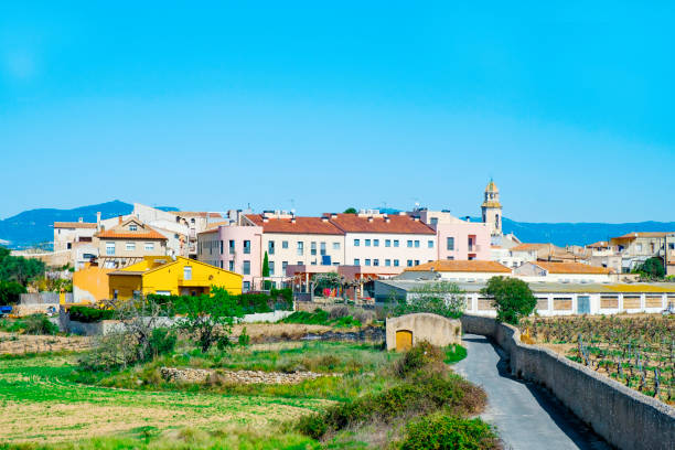 a view of Nulles, a small farming village in Tarragona Province in Catalonia, Spain, higlighting the bell tower of its church, dedicated to Saint John the Baptist