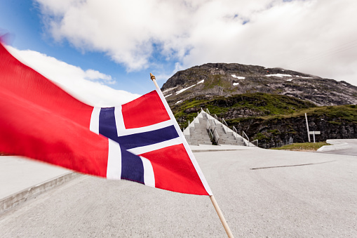 Norwegian flag against Utsikten viewpoint at Gaularfjellet. Tourist attraction. Scenic route in Norway.