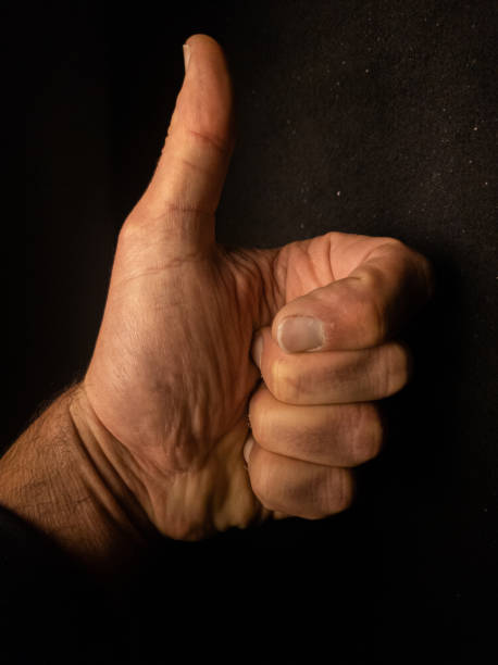 istock human hand palm with thumb up under dark background.  hitchhiking or cool symbol. 1313977111