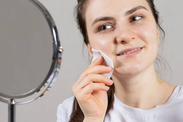 25-letnia kobieta trzyma tonik na twarzy i szyi oraz wacik. przeciwzmarszczkowa pielęgnacja skóry, witaminy i kwasy do twarzy. - 2519 zdjęcia i obrazy z banku zdjęć