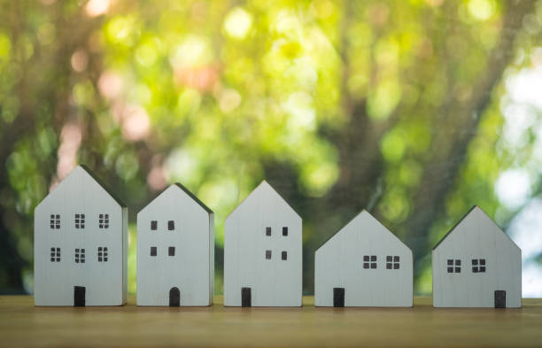 modelos de madera de diferentes tamaños de casas sobre mesa con fondo verde. el concepto de tamaño de la casa se puede permitir. - various sizes fotografías e imágenes de stock