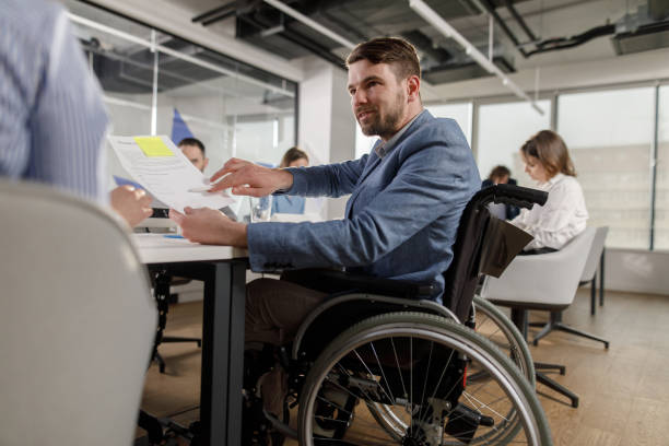 istock Happy disabled businessman working on paperwork with his colleague. 1313980471