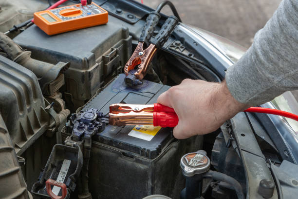 istock Hands of car mechanic using car battery jumper cable to start-up engine 1313981857