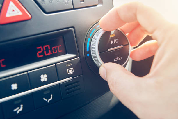 man hand set the temperature of air conditioner in the car. driver turning on car climate control system. travel by car. close up view with selective focus. - car air conditioner vehicle interior driving imagens e fotografias de stock