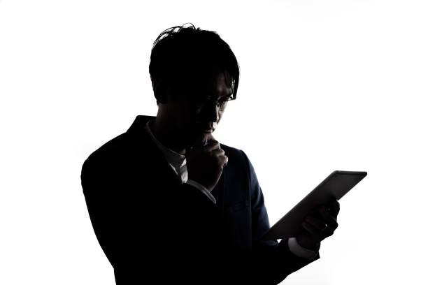 istock Silhouette of businessman use tablet isolate on  white background. 1313990562