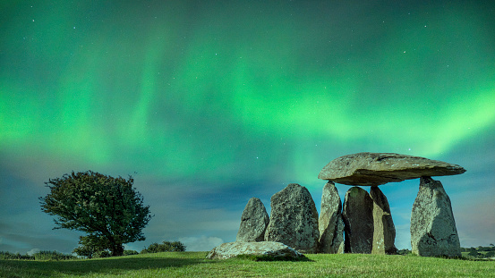 Remnants of a Neolithic burial chamber, in the evening with beautiful green northern lights. Imagine the druids