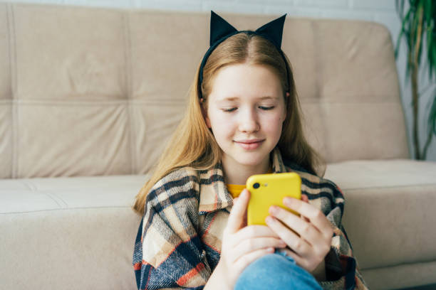 istock A schoolgirl in cat ears communicates on a mobile phone. 1313993055