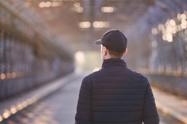 istock Lonely man walking on bridge at sunrise 1313995568