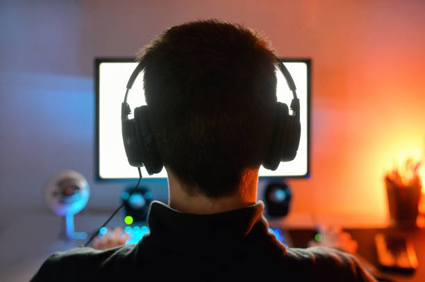 istock Young Man Playing A Video Game shoot from Behind 1313996247