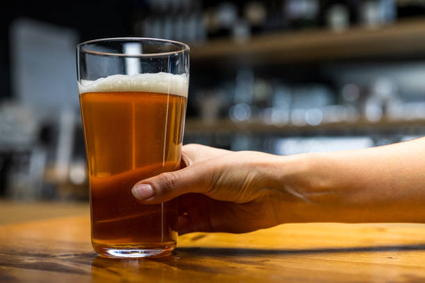 istock Barman keeping beer glass on table 1313999886