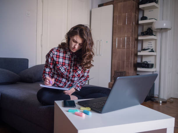 istock one young woman, working at home, writing notes in a book. 1314004807
