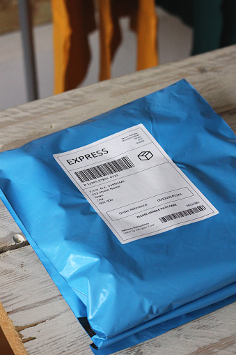 A blue mailing bag parcel with a fictional express label on.