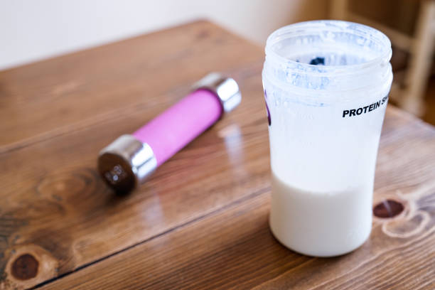 protein drink and dumbbell on wooden table - healthy eating food and drink nutrition label food imagens e fotografias de stock