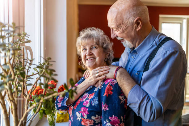 istock Senior couple embracing in front of window 1314006885