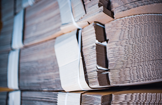 Close-up sides of stacks of cardboard folded on top of each other. Concept storage of boxes of environmentally friendly and renewable material. Advertising space