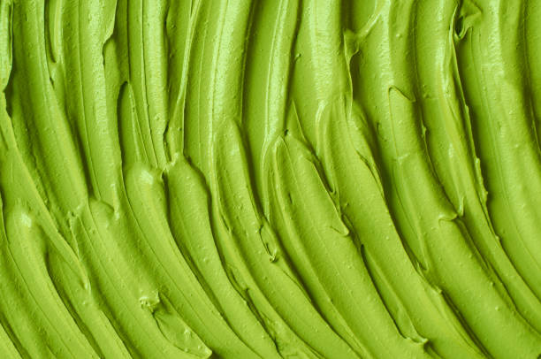 istock Green cosmetic clay (cucumber facial mask, avocado face cream, matcha body wrap) texture close up, selective focus. Abstract background with brush strokes. 1314007106