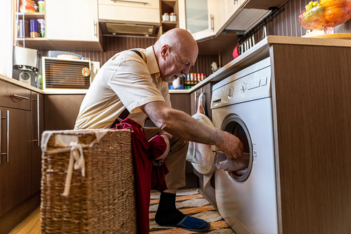 Senior man doing the laundry at home