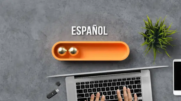 Photo of stylized loading bar with the word SPANISH in Spanish and office equipment