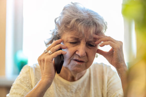 foto de una mujer mayor cansada usando un teléfono móvil - portrait senior adult confusion women fotografías e imágenes de stock