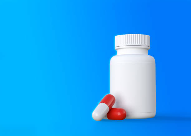 istock Red-white tablets with a pharmacy bottle on a blue background 1314010948