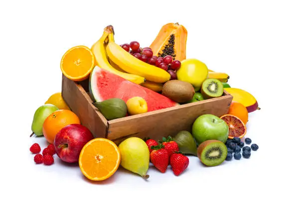 Healthy fresh fruits in a wooden crate isolated on white background. The composition includes mango, banana, apple, fig, orange, kiwi, blueberry, lime, grape, strawberry, pear, peach, papaya, watermelon among others. High resolution 42Mp studio digital capture taken with Sony A7rII and Sony FE 90mm f2.8 macro G OSS lens