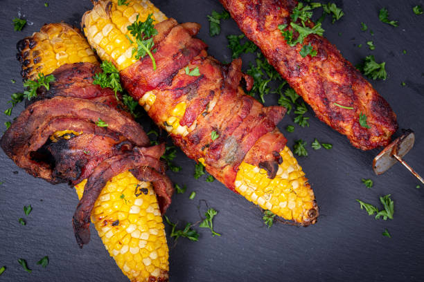 вкусная кукуруза на поб, завернутый в бекон - corn corn on the cob grilled roasted стоковые фото и изображения